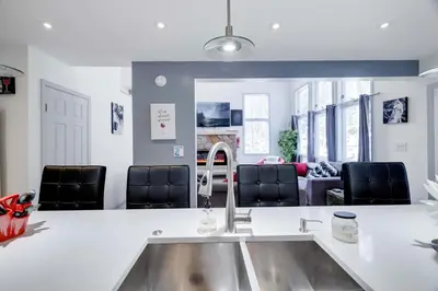 a kitchen with a sink and a living room at Husky Hideaway-Hot Tub, 1 Mile Lake & Ski in Lake Harmony