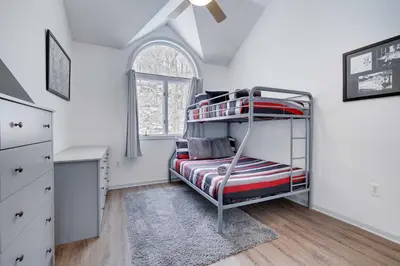 a bedroom with a bunk bed and a window at Husky Hideaway-Hot Tub, 1 Mile Lake & Ski in Lake Harmony