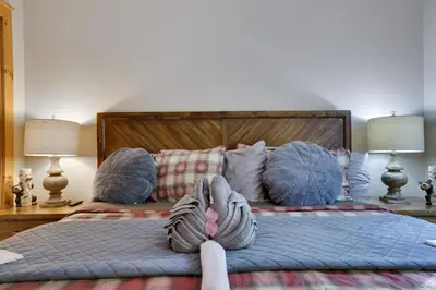 a bed with a person with their feet up on it at Mountainview Vista 1 Mile to Water Park & Ski in Tannersville