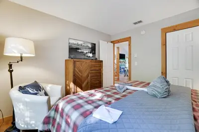 a bedroom with a bed and a chair and a lamp at Mountainview Vista 1 Mile to Water Park & Ski in Tannersville