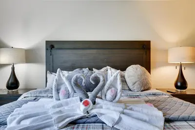 a bed with towels on it with two swan pillows at Mountainview Vista 1 Mile to Water Park & Ski in Tannersville