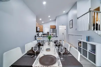 a dining room with a table and white chairs at Lakeside Escape Hot Tub Private Dock Ski in Tobyhanna