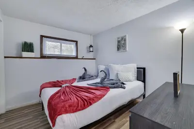 a bedroom with a bed with a red blanket on it at Lakeside Escape Hot Tub Private Dock Ski in Tobyhanna