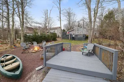 a large wooden deck with chairs and a campfire at Lakeside Escape Hot Tub Private Dock Ski in Tobyhanna