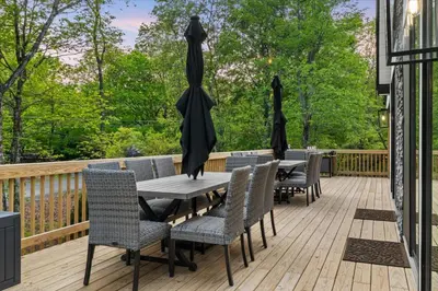 a deck with tables and chairs and umbrellas at Pickleball & Basketball Court Hot Tub Luxury in Albrightsville