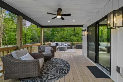 a screened porch with chairs and a ceiling fan at Pickleball & Basketball Court Hot Tub Luxury in Albrightsville