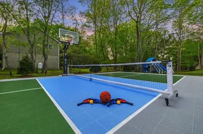 a basketball hoop with a ball laying on a court at Pickleball & Basketball Court Hot Tub Luxury in Albrightsville