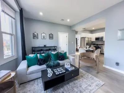 a living room with a couch and a table at Stylish Secret, 1 FREE Parking, Sleeps 8, Walk to train and Red Bull Arena, 20 Percent OFF in Harrison