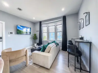 a living room with a couch and a table at Stylish Secret, 1 FREE Parking, Sleeps 8, Walk to train and Red Bull Arena, 20 Percent OFF in Harrison