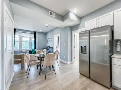 a kitchen and dining room with a table and a refrigerator at Stylish Secret, 1 FREE Parking, Sleeps 8, Walk to train and Red Bull Arena, 20 Percent OFF in Harrison