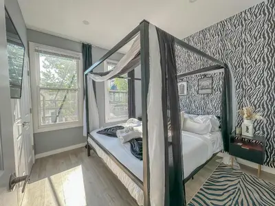 a bedroom with a canopy bed in a room at Stylish Secret, 1 FREE Parking, Sleeps 8, Walk to train and Red Bull Arena, 20 Percent OFF in Harrison