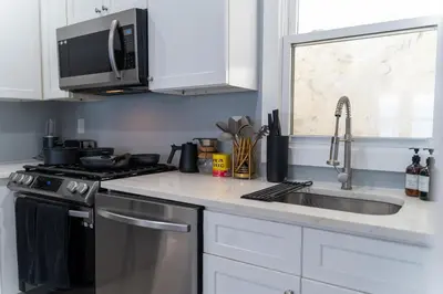a kitchen with a sink and a stove and a microwave at Stylish Secret, 1 FREE Parking, Sleeps 8, Walk to train and Red Bull Arena, 20 Percent OFF in Harrison