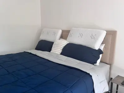 a bed with blue and white sheets and pillows at Cozy Budd Lake Cul-de-Sac Home Lodge in Mount Olive