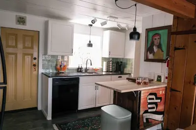 a kitchen with white cabinets and a black dishwasher at Mountain Laurel Bungalow Lakeview & Ski in Lake Harmony
