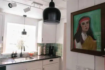 a kitchen with a painting of a woman on the wall at Mountain Laurel Bungalow Lakeview & Ski in Lake Harmony