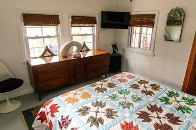 a bedroom with a quilt on a bed and a dresser at Mountain Laurel Bungalow Lakeview & Ski in Lake Harmony