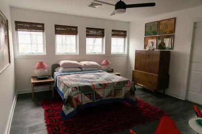 a bedroom with a bed and a dresser and windows at Mountain Laurel Bungalow Lakeview & Ski in Lake Harmony