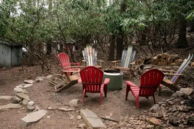 four red chairs and a table in a yard at Mountain Laurel Bungalow Lakeview & Ski in Lake Harmony