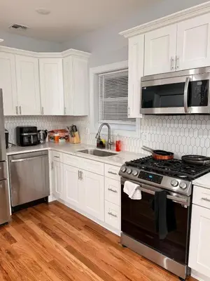 a kitchen with white cabinets and a stove top oven at The great homes in East Orange