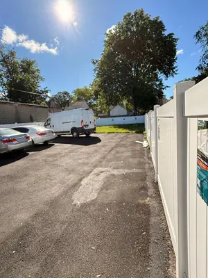 a van parked in a parking lot next to a fence at The great homes in East Orange