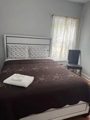 a bedroom with a large bed and a chair at The great homes in East Orange