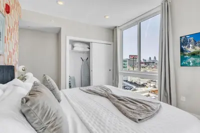 a bedroom with a white bed and a large window at Lux 2BD with KINGS - Pier Views - Near Fishtown! in Philadelphia