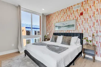 a bedroom with a bed and a large window at Lux 2BD with KINGS - Pier Views - Near Fishtown! in Philadelphia