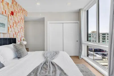 a bedroom with a bed and a large window at Lux 2BD with KINGS - Pier Views - Near Fishtown! in Philadelphia