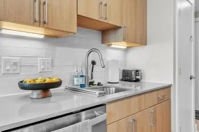a kitchen with a sink and a bowl of fruit at Luxe Studio with City Views - Near Fishtown in Philadelphia