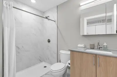 a bathroom with a shower and a toilet and a sink at Luxe Studio with City Views - Near Fishtown in Philadelphia