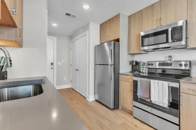 a kitchen with stainless steel appliances and wooden cabinets at Scenic City Studio - Walkable - Smart TV in Philadelphia