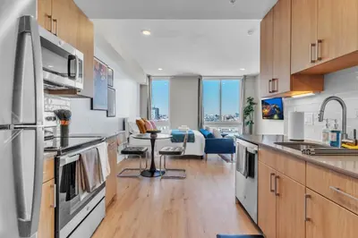a kitchen with wooden cabinets and a table with chairs at Scenic City Studio - Walkable - Smart TV in Philadelphia