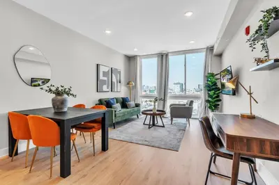 a living room with a black table and orange chairs at Serene 1BD Escape - Stunning City Views! in Philadelphia