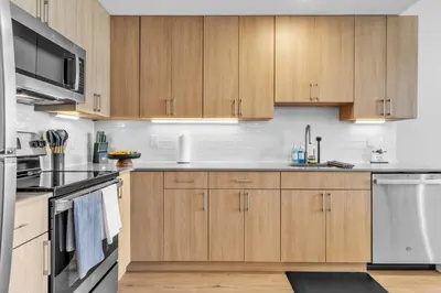 a kitchen with wooden cabinets and stainless steel appliances at Serene 1BD Escape - Stunning City Views! in Philadelphia