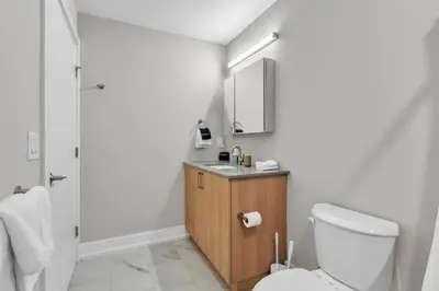 a bathroom with a toilet and a sink and a mirror at Serene 1BD Escape - Stunning City Views! in Philadelphia