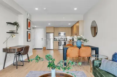 a kitchen and living room with a couch and a table at Serene 1BD Escape - Stunning City Views! in Philadelphia