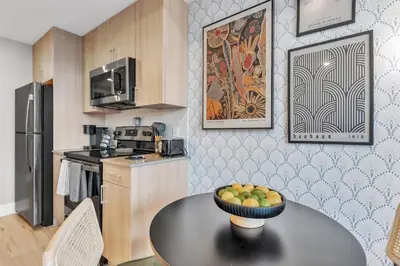 a kitchen with a table with a bowl of fruit on it at Waterfront Studio - Steps from Fishtown and Old City in Philadelphia