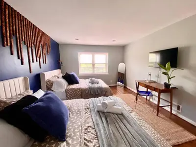 a room with two beds and a desk in it at Easy PATH&Bus access- NYC| designer home + Deck. in Jersey City