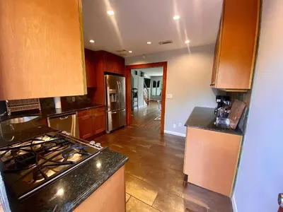 a kitchen with wooden cabinets and a stove top oven at Easy PATH&Bus access- NYC| designer home + Deck. in Jersey City
