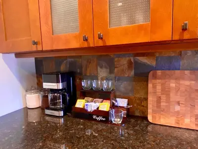 a kitchen counter with glasses and a coffee maker at Easy PATH&Bus access- NYC| designer home + Deck. in Jersey City