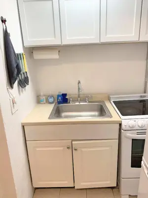 a kitchen with white cabinets and a sink at Chelsea Studio-Shared Bathroom with Kitchen Twin Bunk Bed in New York