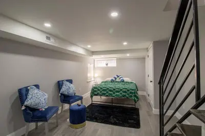 a bedroom with a bed and two blue chairs at Home in Philadelphia Stadium nearby in Philadelphia