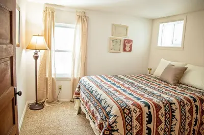 a bedroom with a bed and a lamp and a window at The Farmhouse at Deer Run