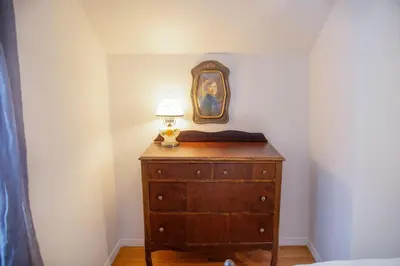 a bedroom with a dresser with a lamp on it at The Farmhouse at Deer Run