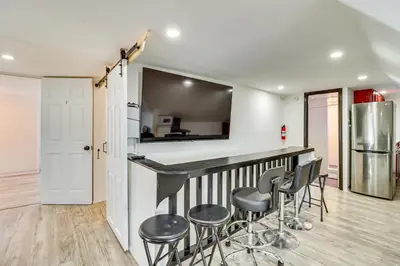a kitchen with a bar with stools in a room at Walkable Abode in Stroudsburgs Business District! in Stroudsburg