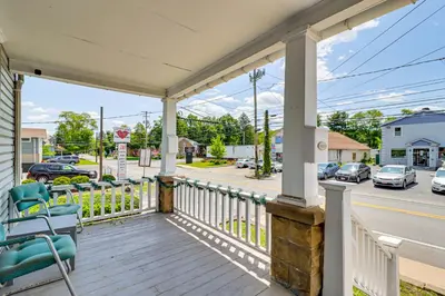 a porch with a blue chair and a street at Walkable Abode in Stroudsburgs Business District! in Stroudsburg
