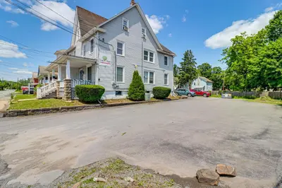a white house with aphalt street in front at Walkable Abode in Stroudsburgs Business District! in Stroudsburg