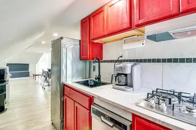 a kitchen with red cabinets and a sink at Walkable Abode in Stroudsburgs Business District! in Stroudsburg