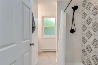 a white bathroom with a shower and a door at Game Room and Deck Family Home in Tobyhanna! in Tobyhanna