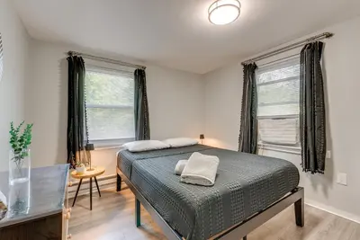 a bedroom with a bed and two windows at Game Room and Deck Family Home in Tobyhanna! in Tobyhanna